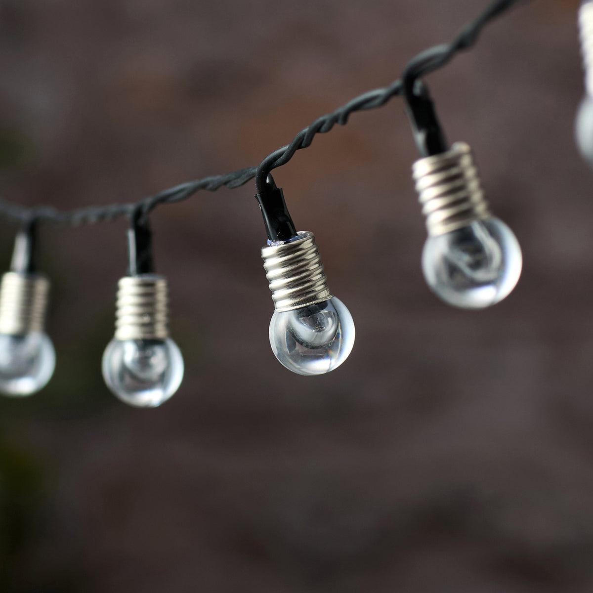 Detailansicht einer klaren Kristallkugel mit LED an schwarzem Kabel der Lichterkette