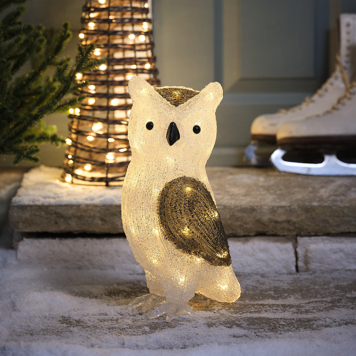 Leuchtende Acryl-Eulenfigur Ollie mit warmweißen LEDs auf verschneiter Steinfläche