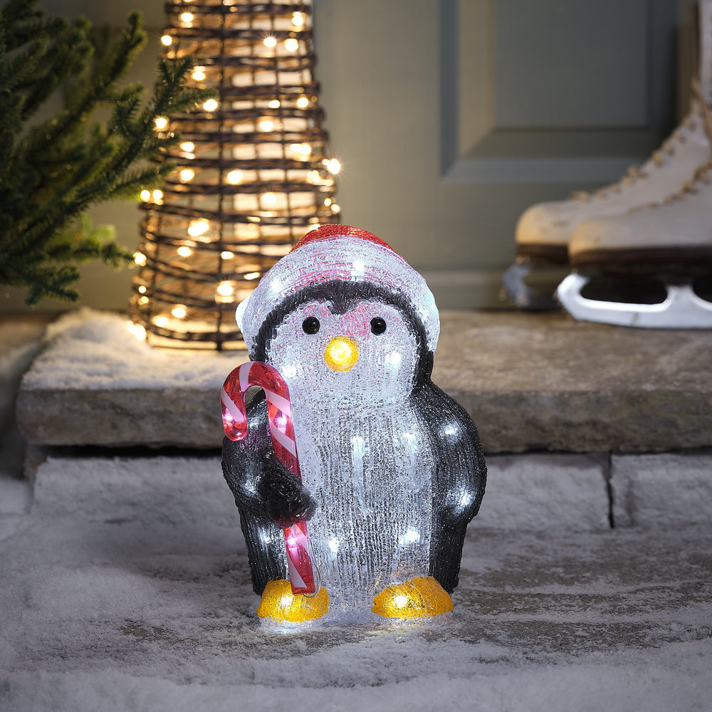 Leuchtende LED-Acryl-Weihnachtsfigur Pinguin mit roter Mütze und Zuckerstange im Flügel