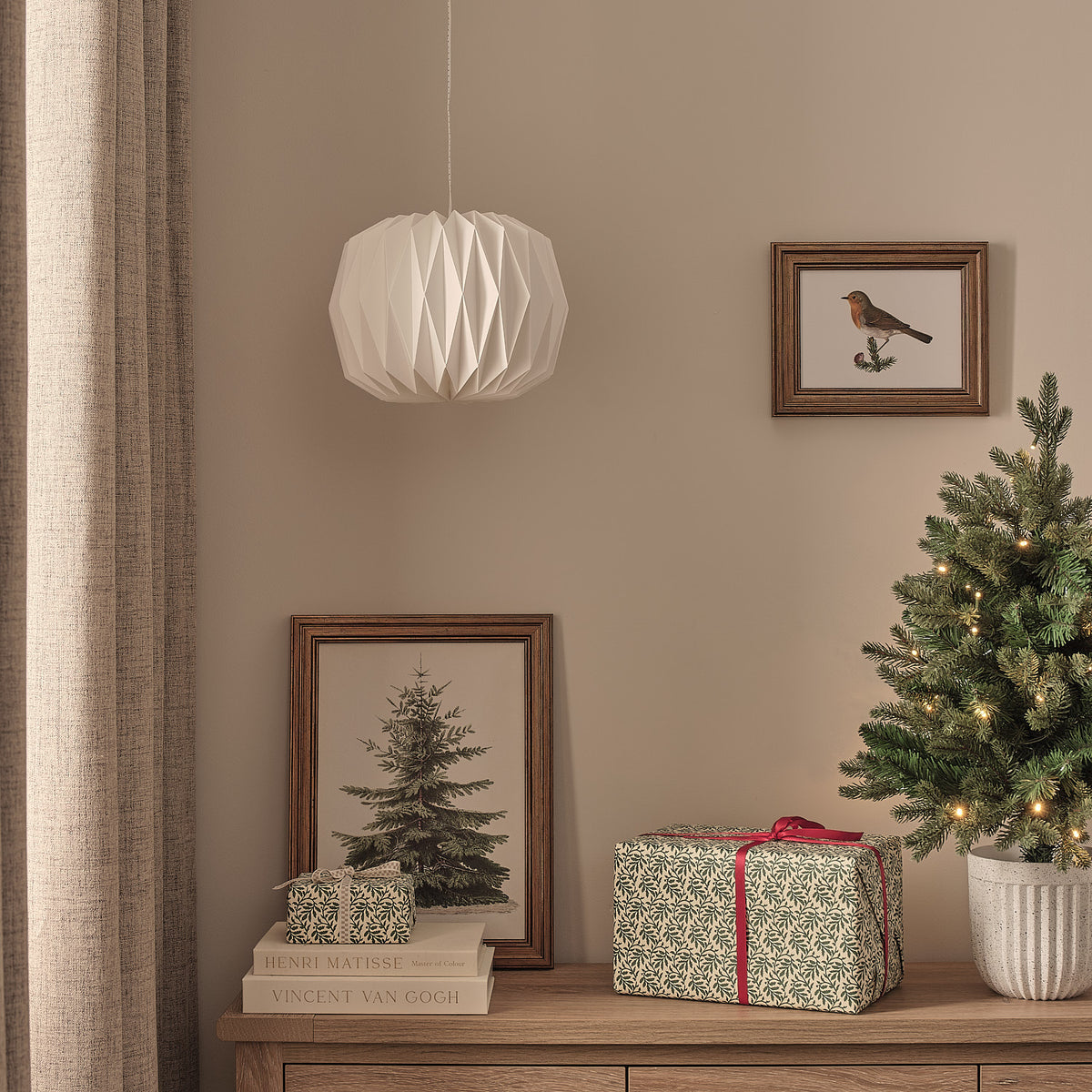 Weiße LED-Papierlaterne ohne Licht an grauer Wand mit Weihnachtsdeko und Geschenken