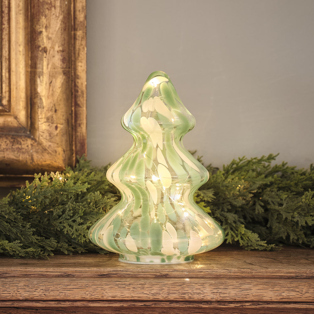 Grüner LED-Deko-Weihnachtsbaum aus Konfettiglas mit warmweißem Licht auf Holzfläche