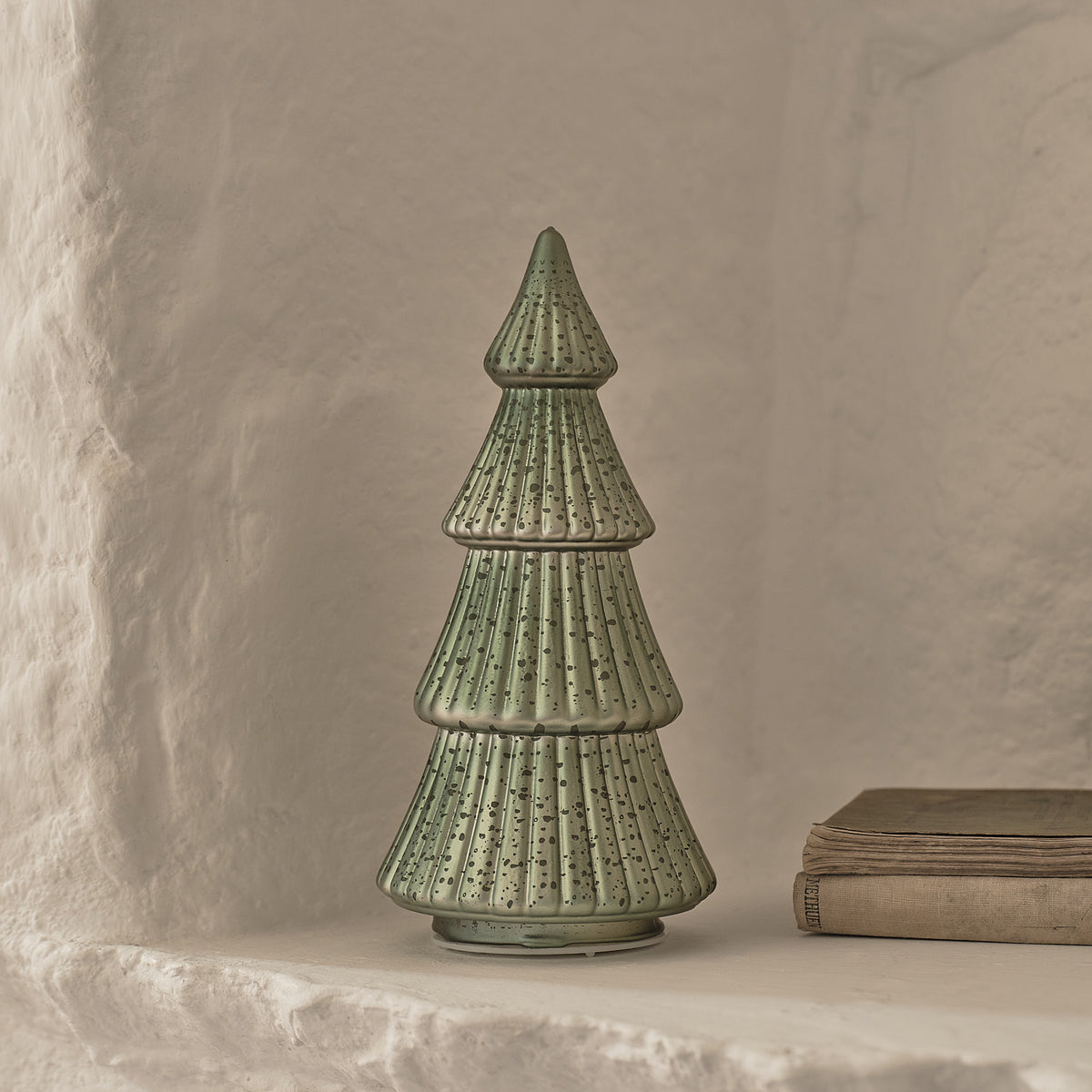 Grüner LED Tannenbaum aus Glas mit Kerzen und beleuchtetem Haus auf silbernem Tablett