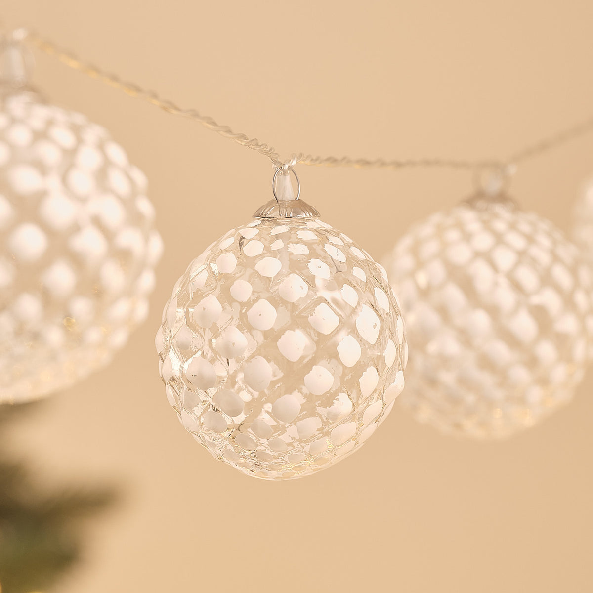 Detailaufnahme einer einzelnen gefrosteten Glaskugel der LED-Schneeball-Lichterkette