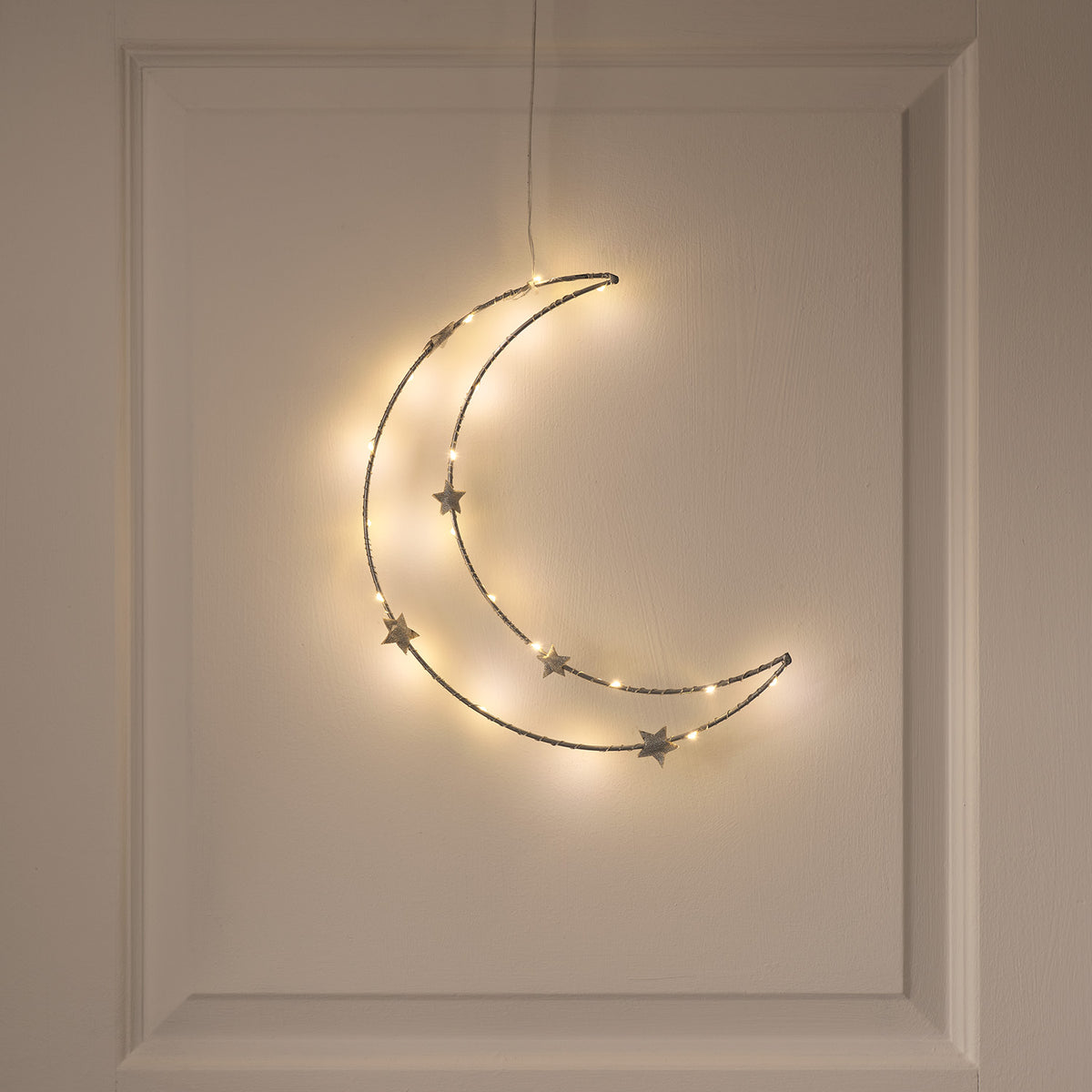 Warmweißer LED-Halbmond mit Sternen zum Aufhängen an weißer Wand