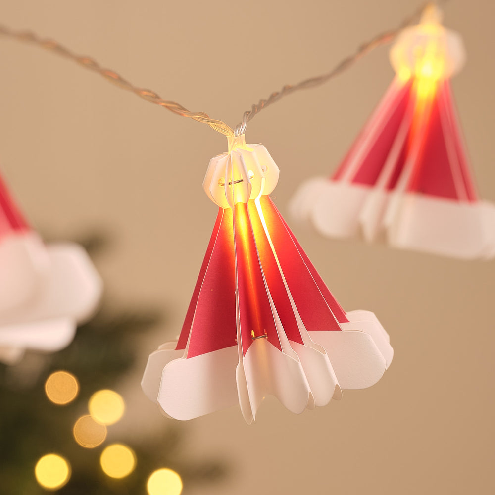 Nahaufnahme einer roten Papier-Weihnachtsmütze mit warmweiß leuchtender LED in Origami-Faltoptik