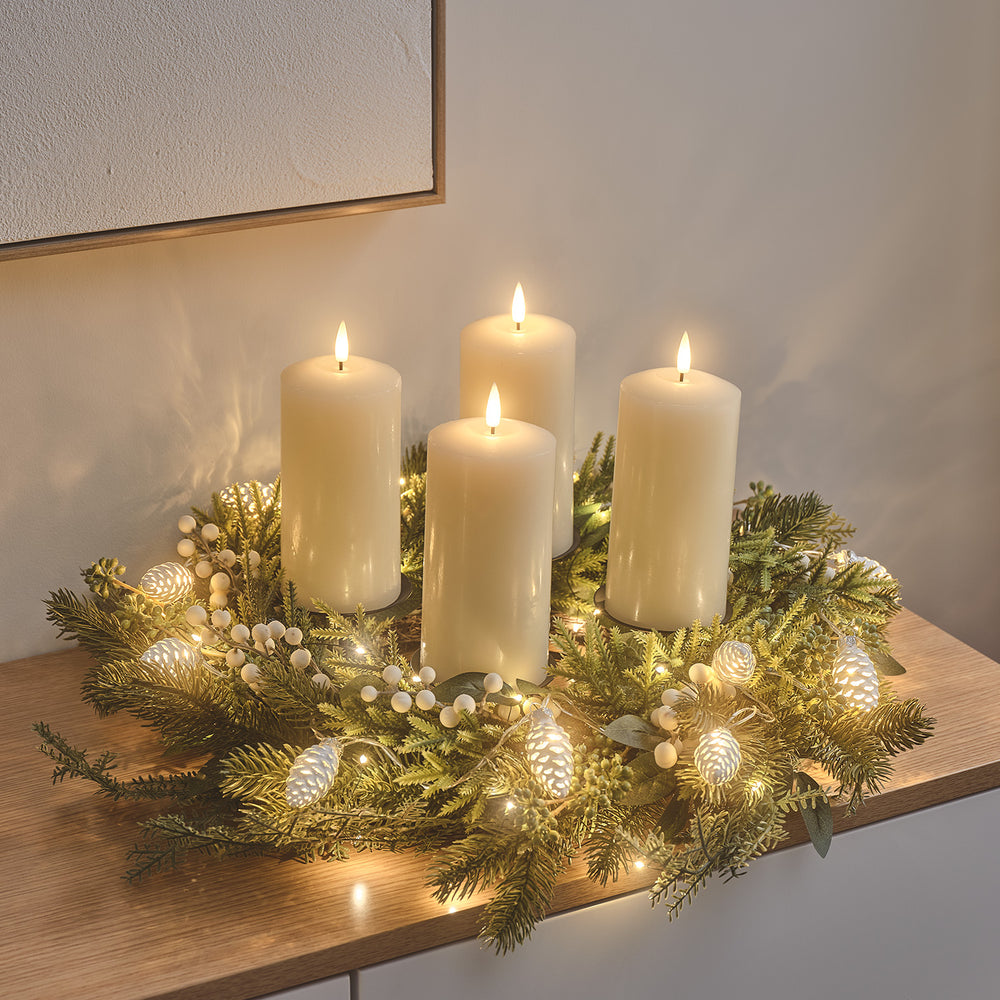 Beleuchteter Weihnachtskranz mit vier weißen TruGlow® LED-Echtwachskerzen auf schwarzem Metall-Kerzenständer