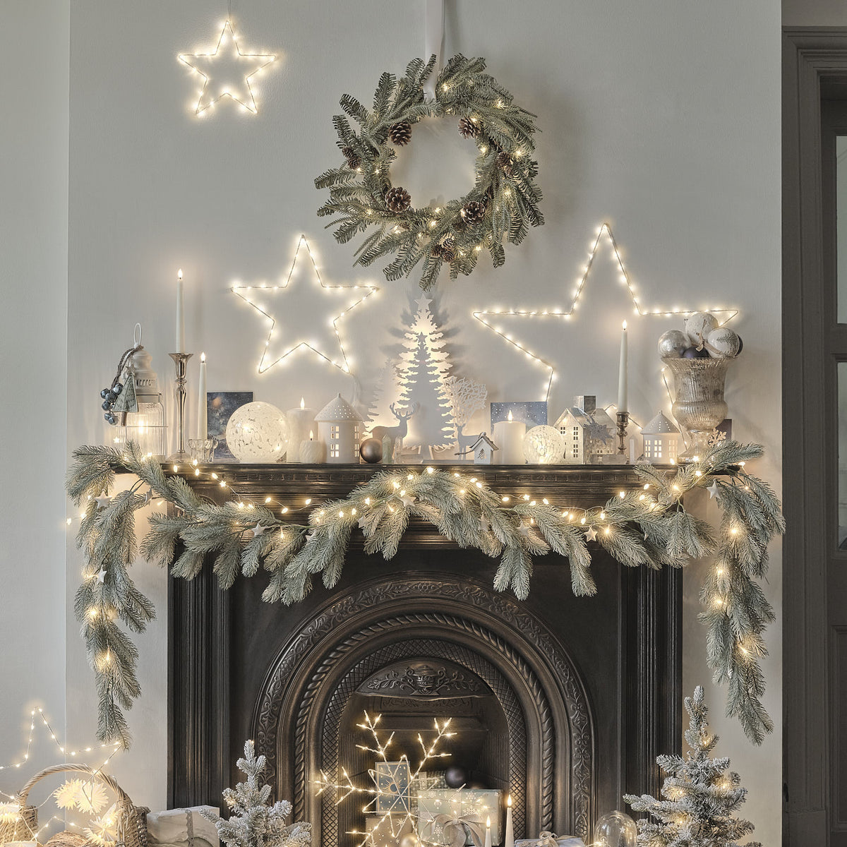Weihnachtliche Kaminumrandung mit Girlande, Kerzen und beleuchtetem LED-Weihnachtskranz