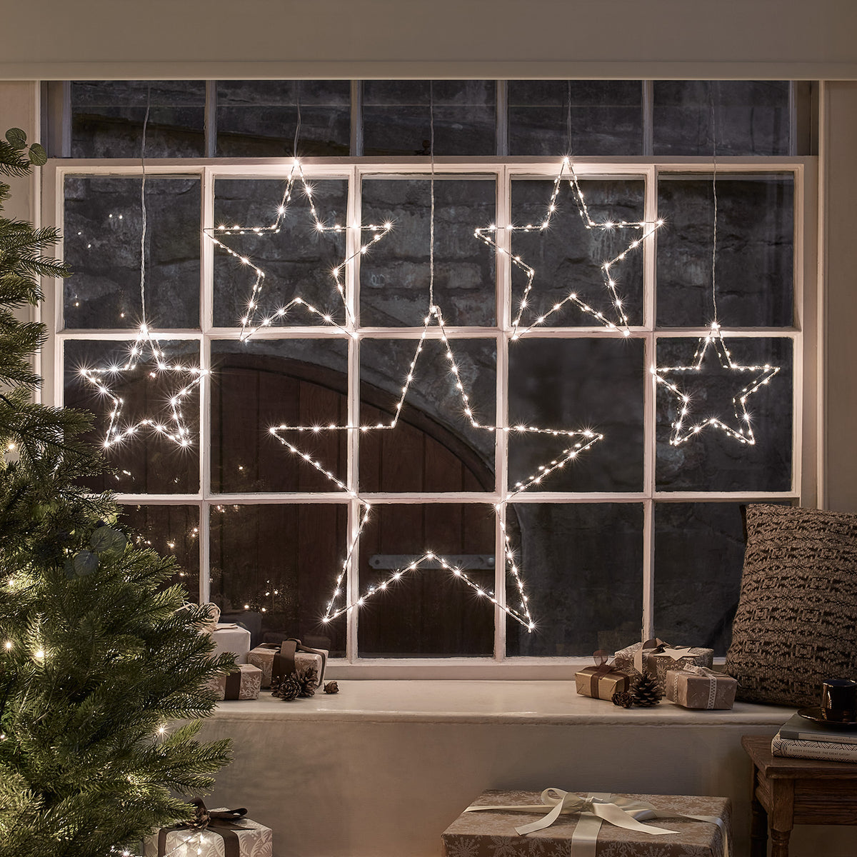 Sternen Lichtervorhang mit fünf weißen Sternen an Fenster, Weihnachtsdeko mit Geschenken und Kissen