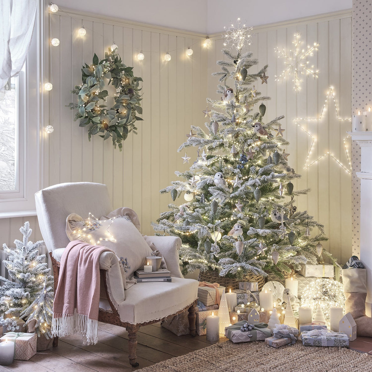 Gemütlich dekoriertes Wohnzimmer mit beleuchtetem Weihnachtsbaum und Geschenken