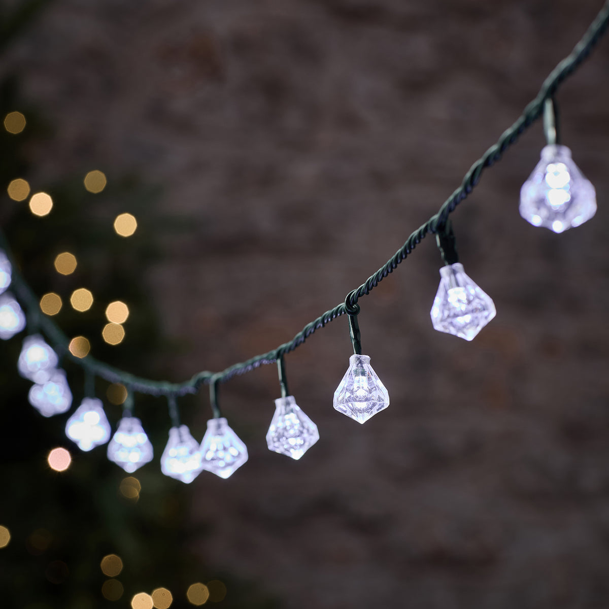 LED-Lichterkette mit weißen und warmweißen Diamantkappen an grünem Kabel