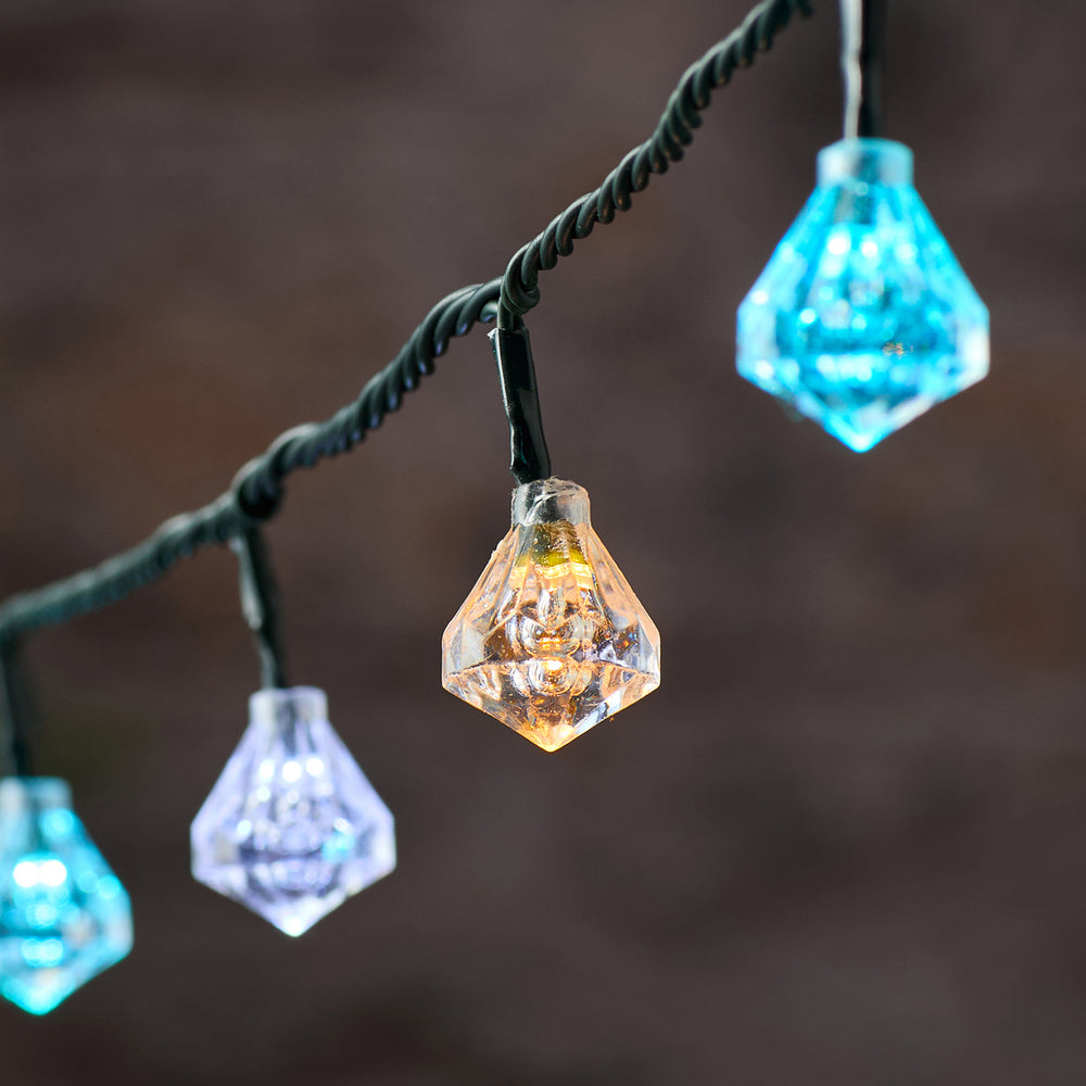 Nahaufnahme einer leuchtenden LED mit facettierter Diamant-Kappe in warmem Gelbton