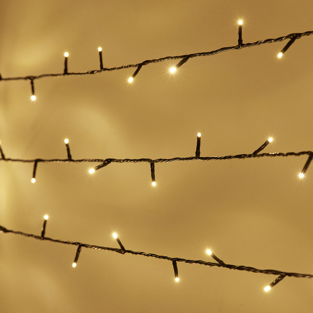 Nahaufnahme der warmweißen LED-Lichterkette mit 100 LEDs an grünem Kabel im Funkeleffekt