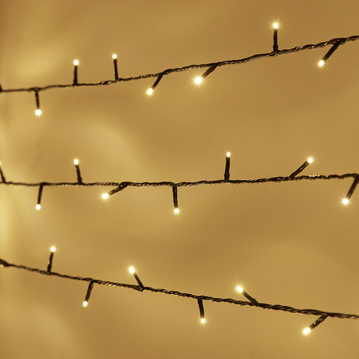 Nahaufnahme der warmweißen LED-Lichterkette mit 100 LEDs an grünem Kabel im Funkeleffekt