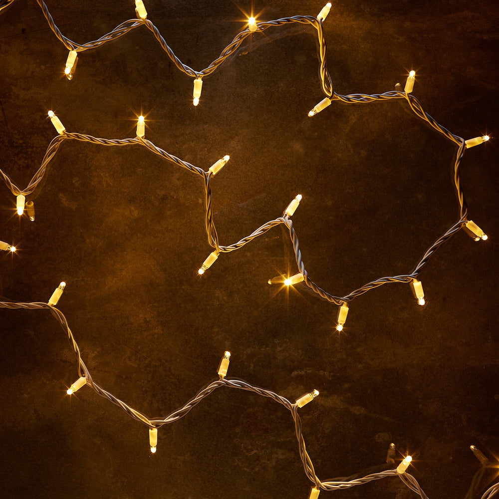 Nahaufnahme der warmweißen LED-Lichterkette mit weißem Kabel auf dunklem Untergrund