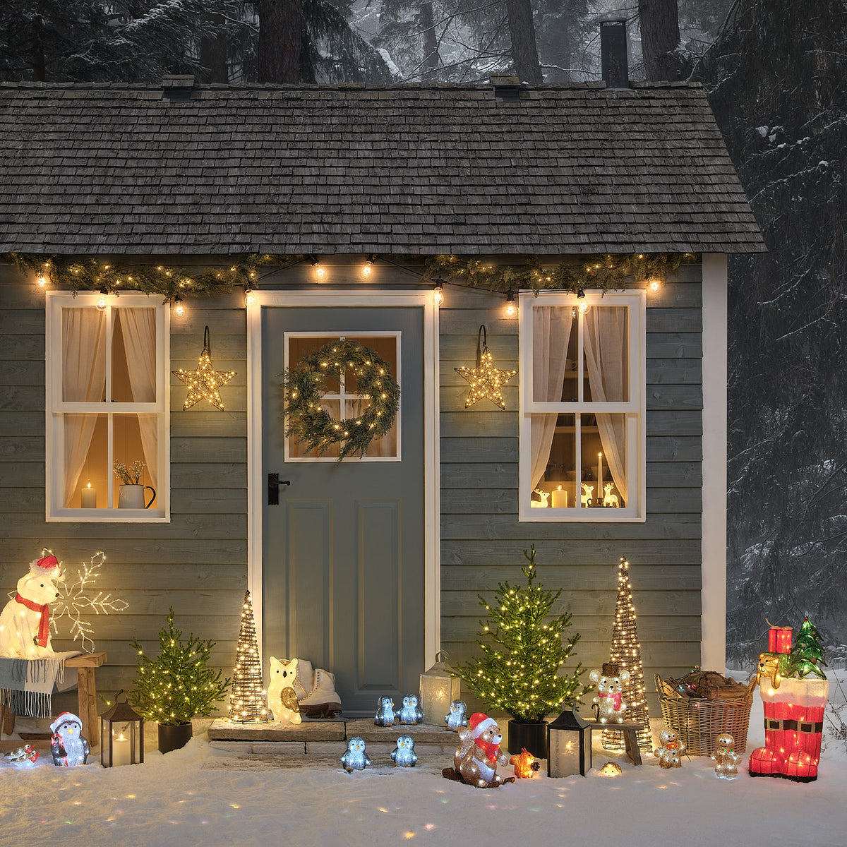 Weihnachtlich dekoriertes Haus mit LED-Lichterketten, Sternen und leuchtenden Acrylfiguren