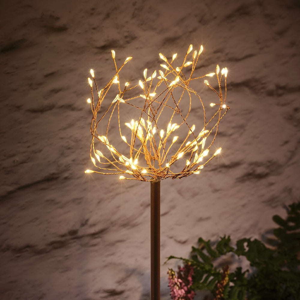 Nahaufnahme einer Micro LED Stableuchte mit warmweiß leuchtenden Blüten und Kupferkabel