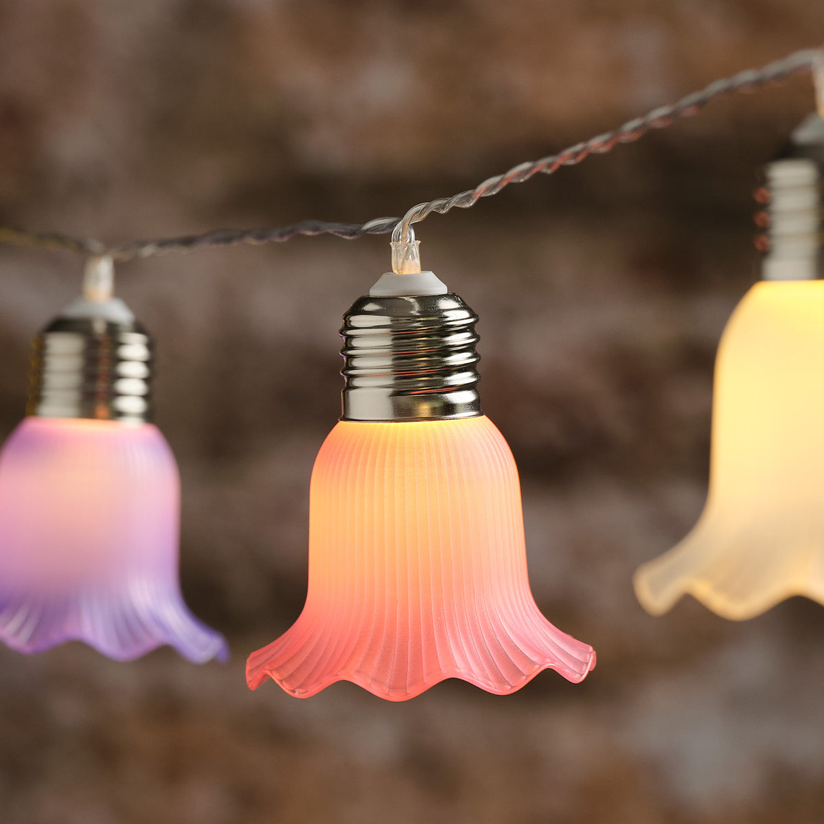Nahaufnahme einer warmweiß leuchtenden pastellfarbenen Blüte der Solar-Lichterkette