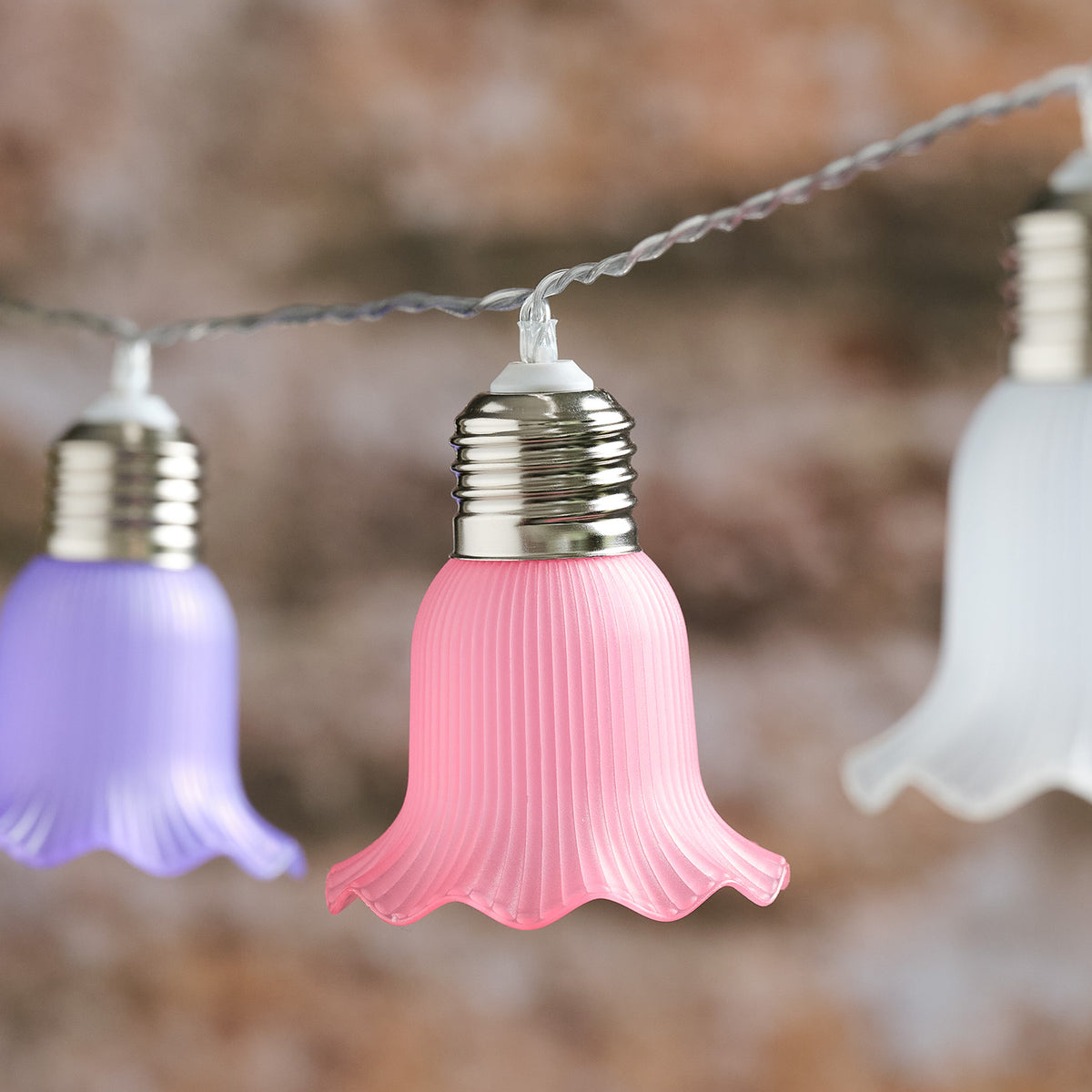 Detailaufnahme einer rosa Blüte der Solar-LED-Lichterkette mit Metallfassung