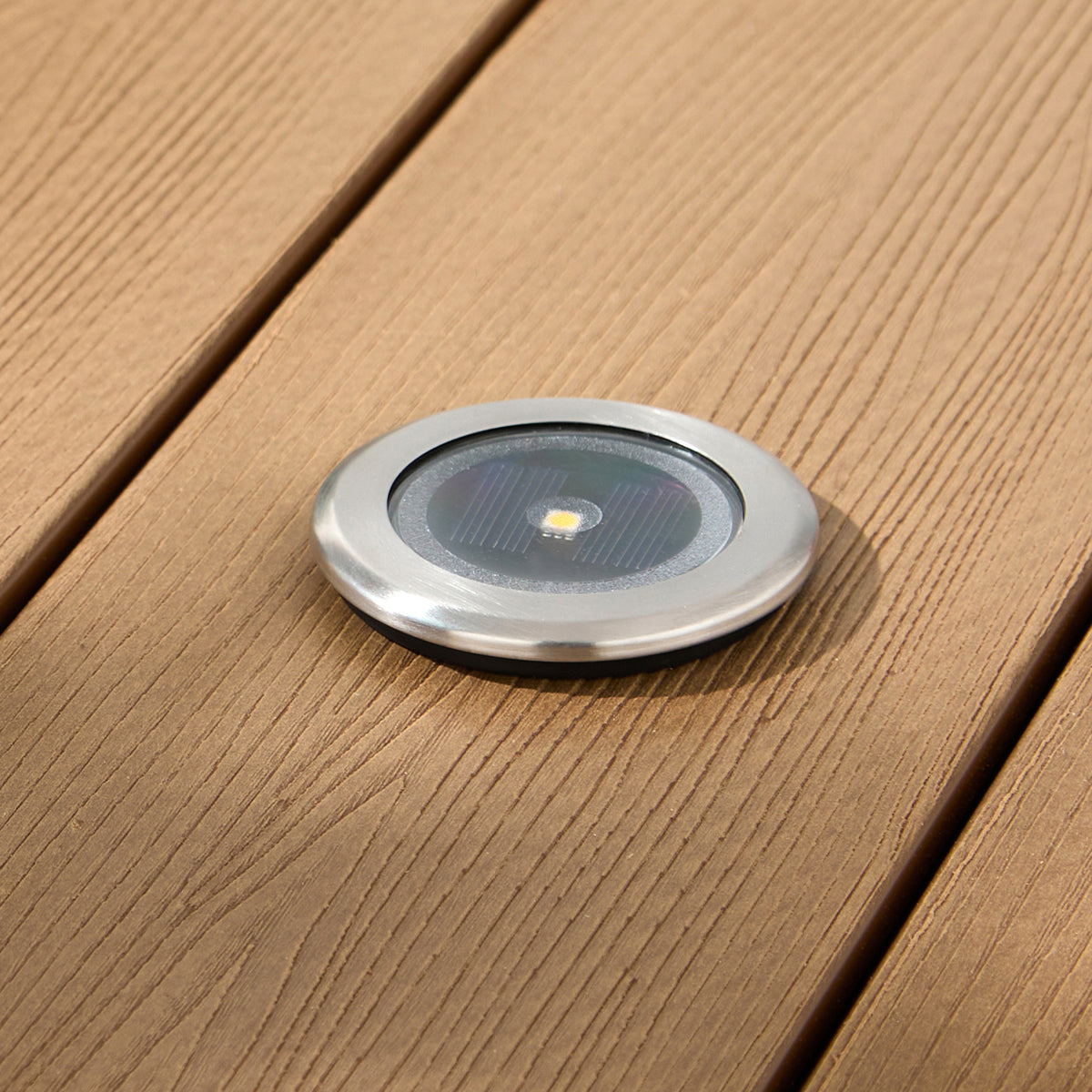 Solar-Terrassenstrahler mit silbernem Rahmen in Holzterrasse neben Rasen