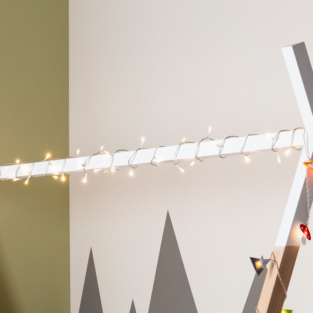 Kinderzimmer mit Tipi-Bett und warmweißer LED-Lichterkette am Bettrahmen