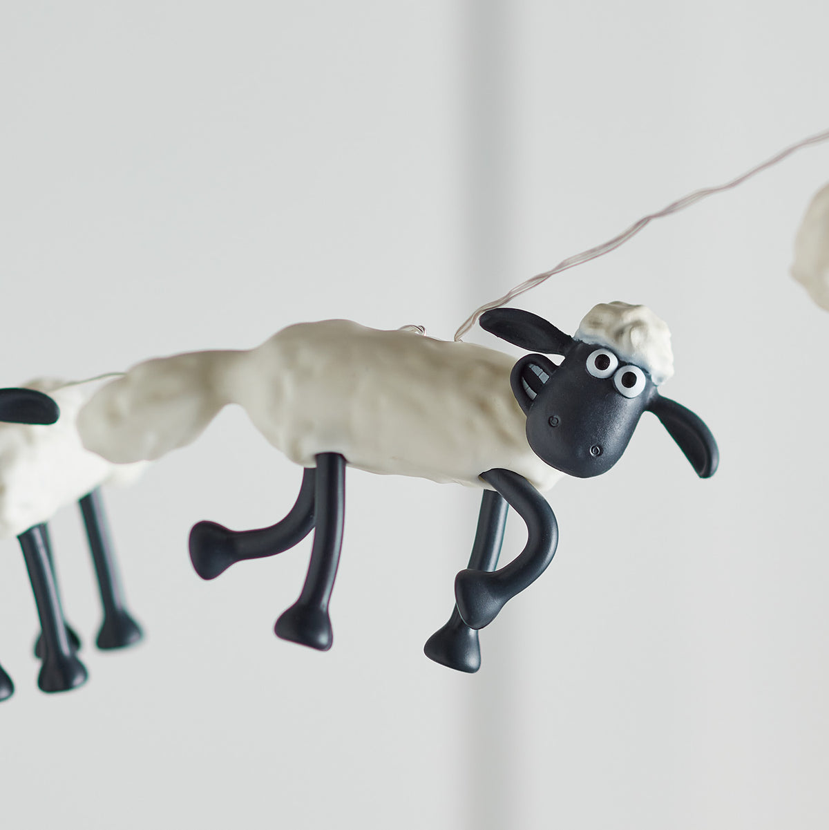 Nahaufnahme einer Shaun the Sheep Figur der Lichterkette ohne Beleuchtung vor hellem Hintergrund
