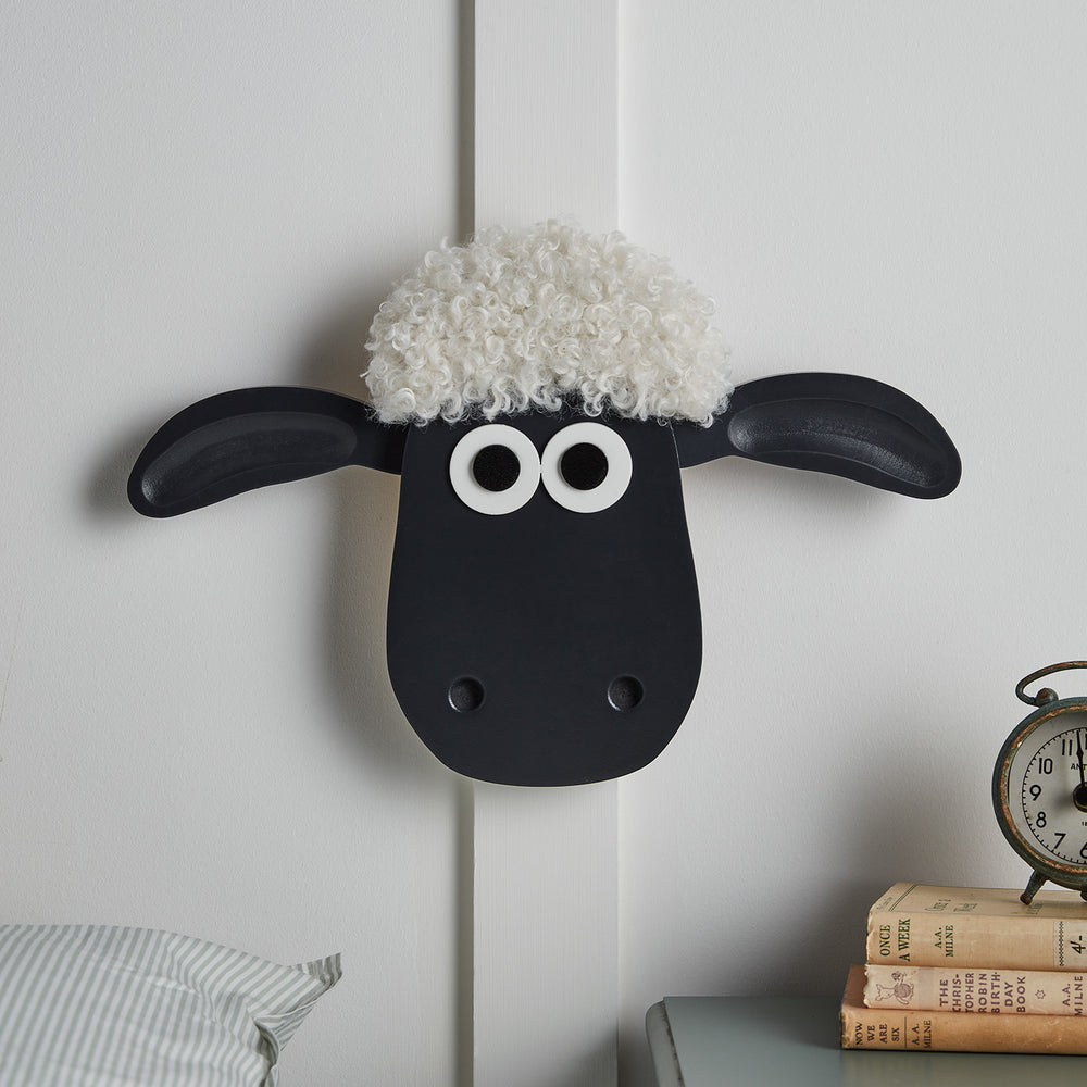 Shaun the Sheep Wandlampe mit schwarzen Ohren und weißen Locken frontal an Wand