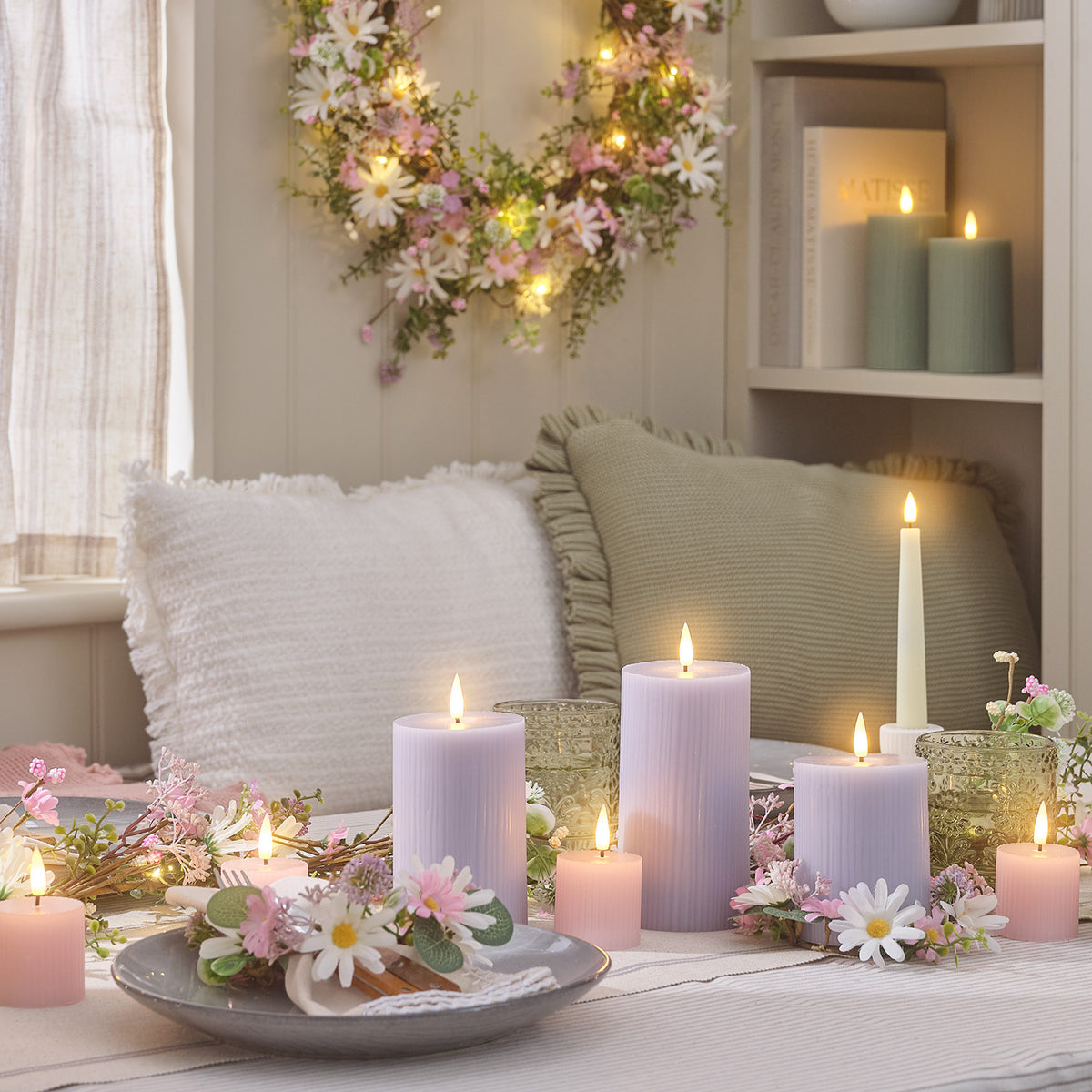 Gemütliche Tischdekoration mit LED-Stumpenkerzen in Flieder und Blumenarrangement