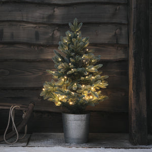 90cm hoher LED-Weihnachtsbaum im Metalltopf vor dunkler Holzwand mit warmweißen Lichtern