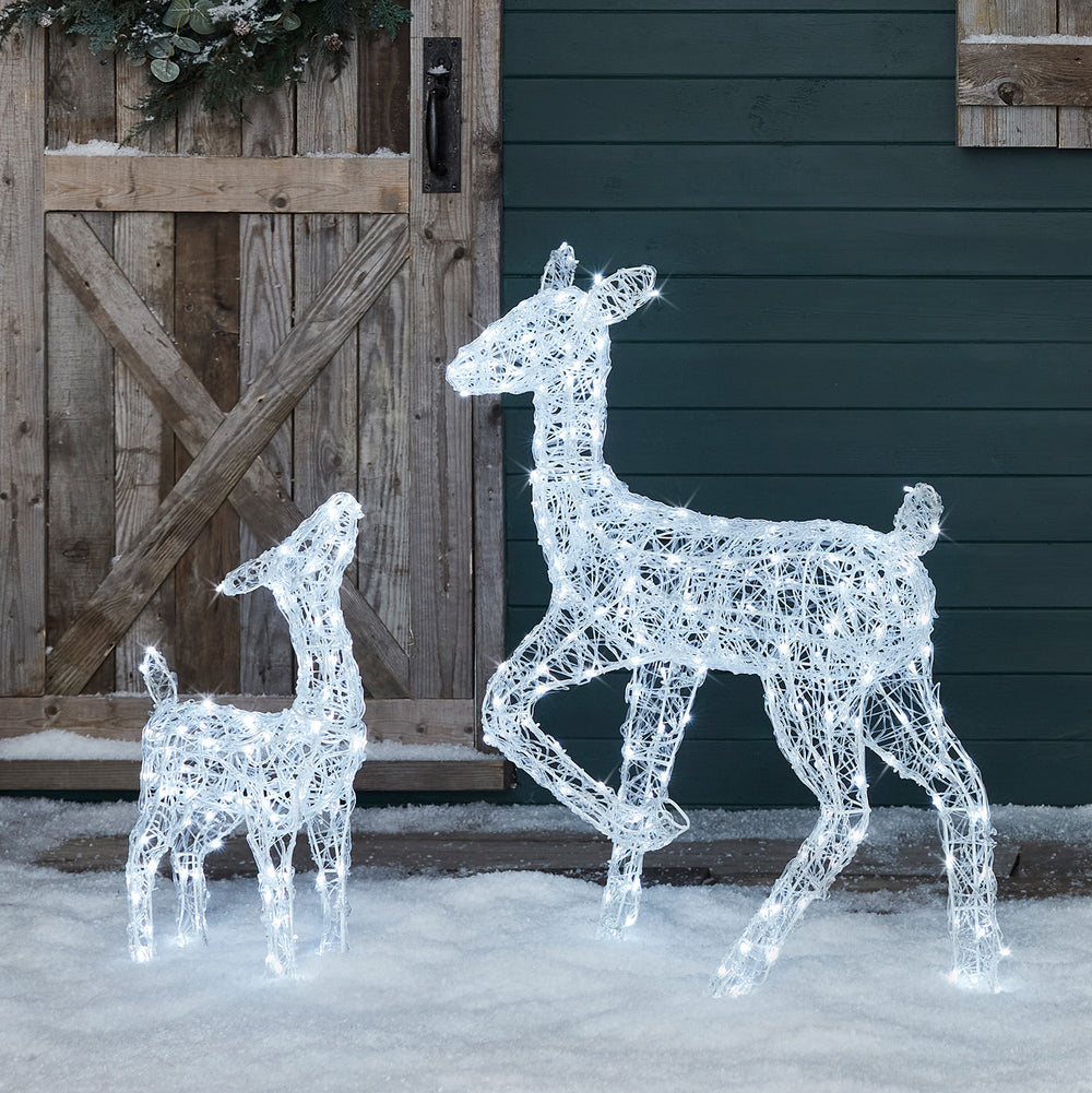 Leuchtende Acryl-Solar-LED-Rentiere Hirschkuh und Rehkitz im Schnee vor Holztür