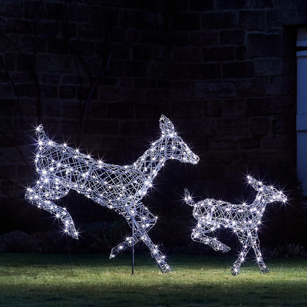 Rattan-Optik Hirschkuh und Rehkitz mit weißen LEDs beleuchtet im Garten bei Nacht