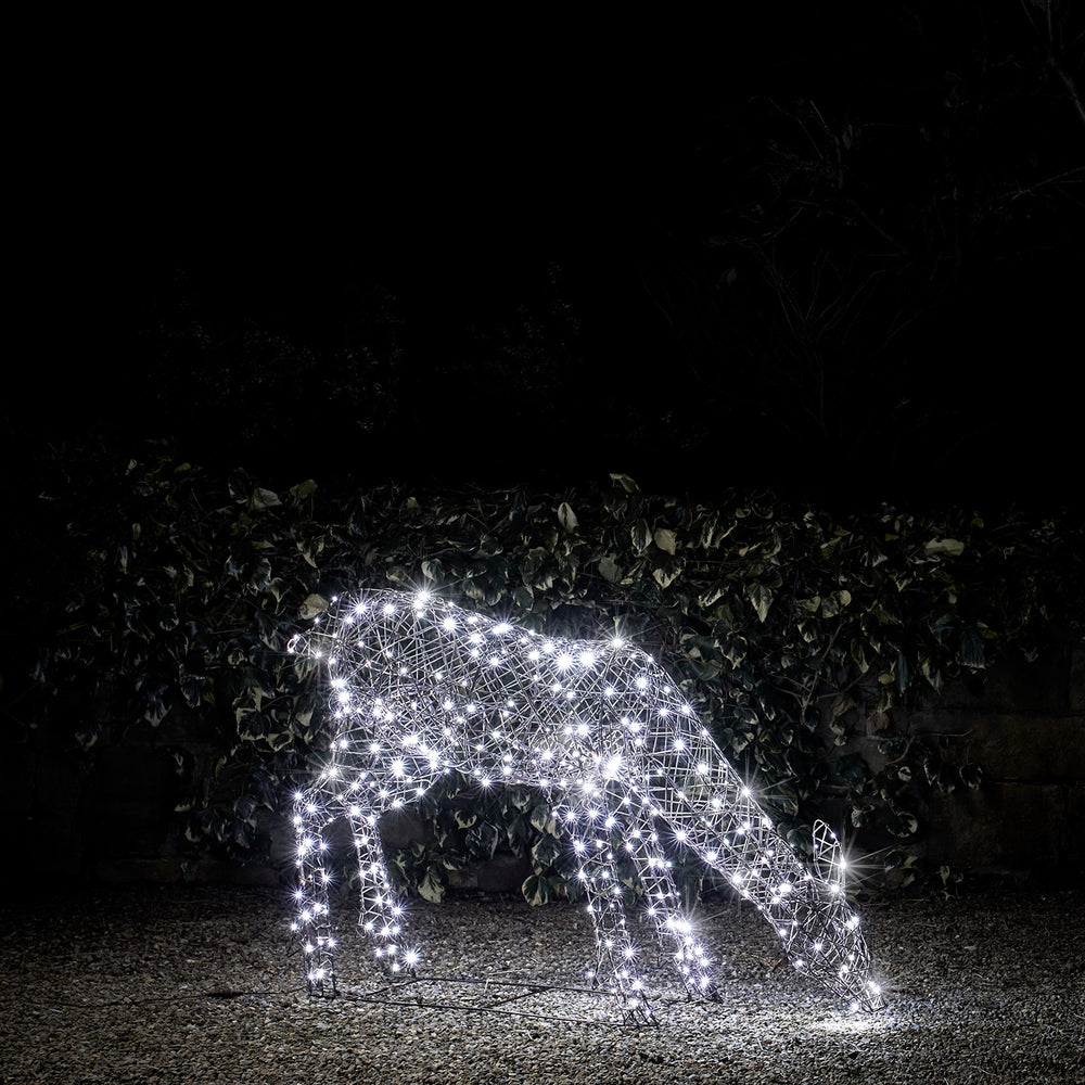 Leuchtende Hirschkuh aus Rattan-Optik mit weißen LEDs im Garten bei Nacht