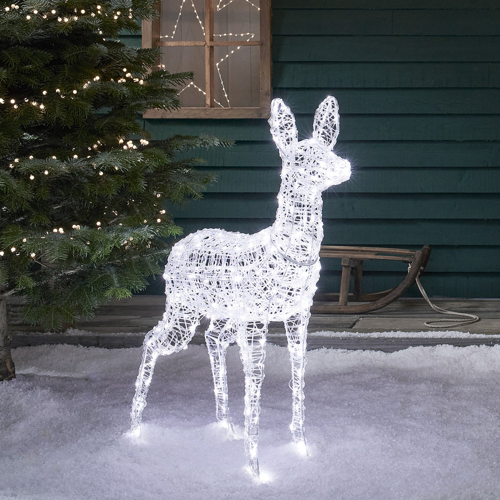 Bicolor LED Rentier Hirschkuh mit weißem Licht vor Hauswand und Tannenbaum