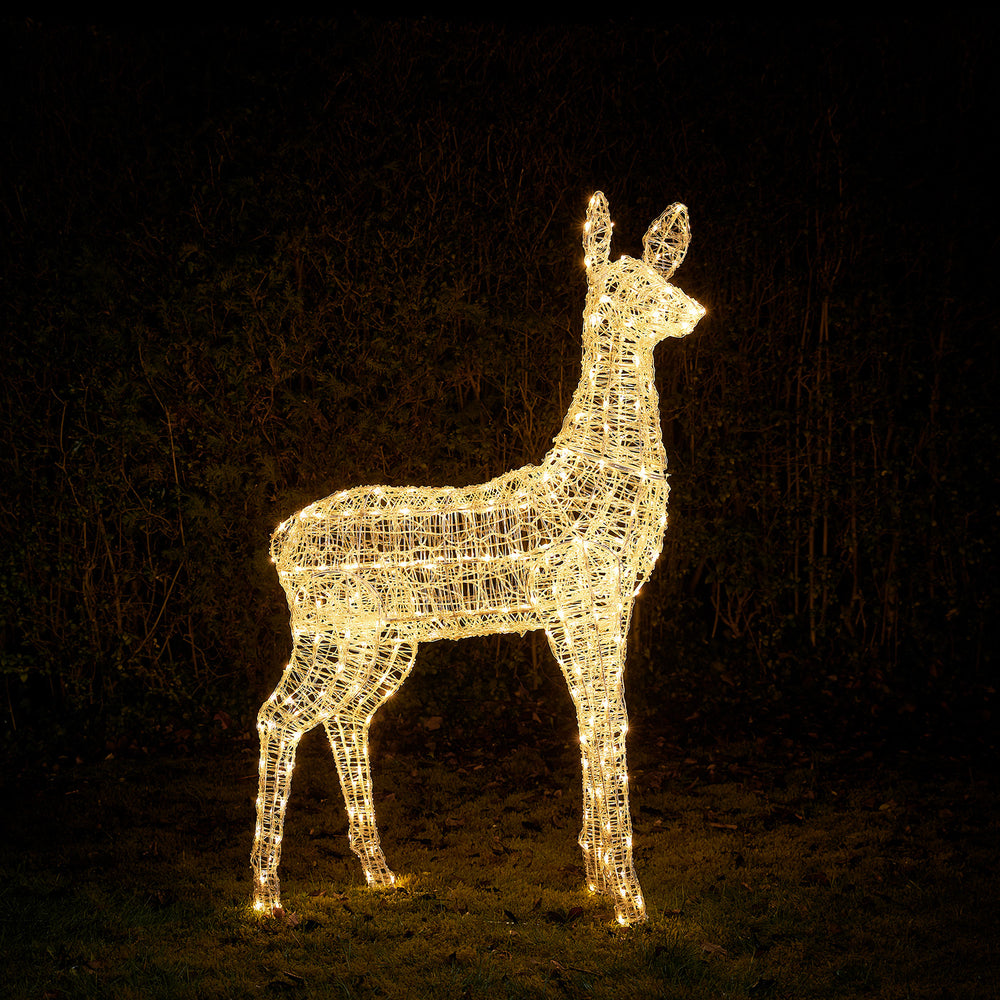 Leuchtendes Rentier aus Metallrahmen mit warmweißen LEDs im Garten bei Nacht