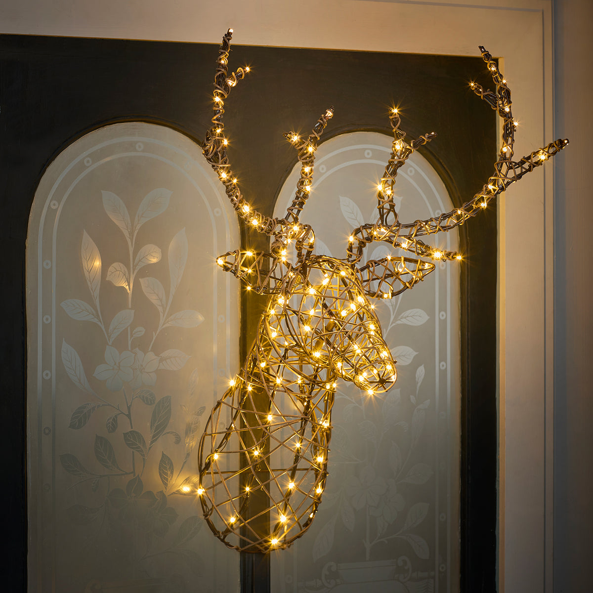 Studley LED Hirschgeweih mit warmweißen LEDs vor dunklem Hintergrund mit floralem Muster