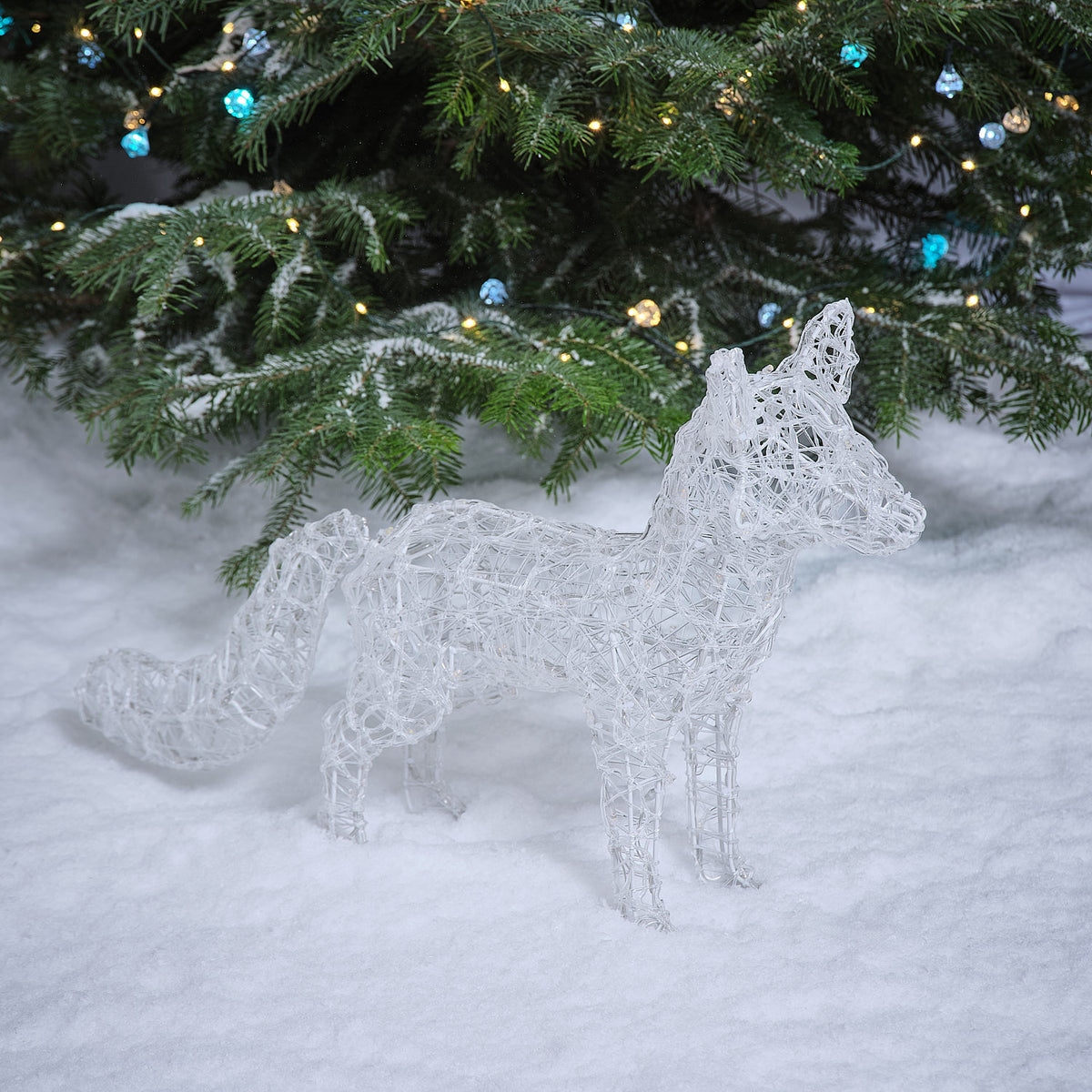 Ausgeschalteter LED Acryl Polarfuchs aus transparentem Acryl im Schnee