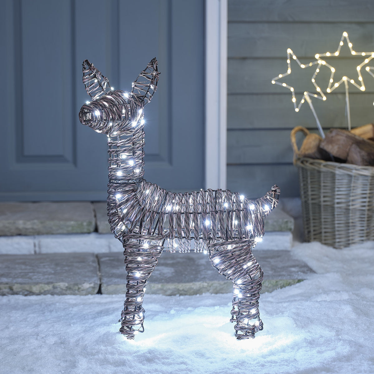 Pateley Bicolor LED-Rehkitz aus Rattan mit 110 LEDs in Kaltweiß vor Haus