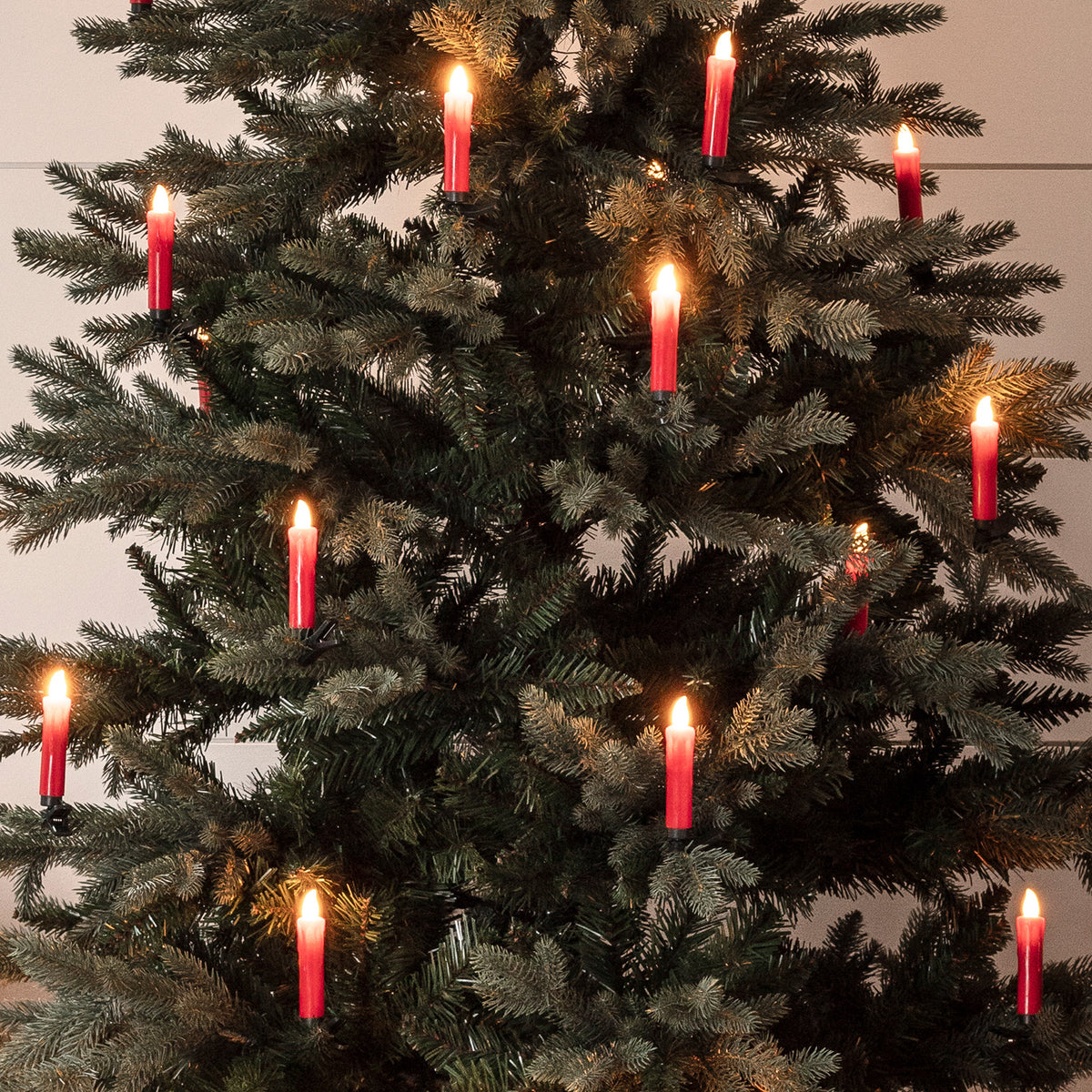 Roter Weihnachtsbaum mit mehreren leuchtenden roten LED-Kerzen an den Zweigen