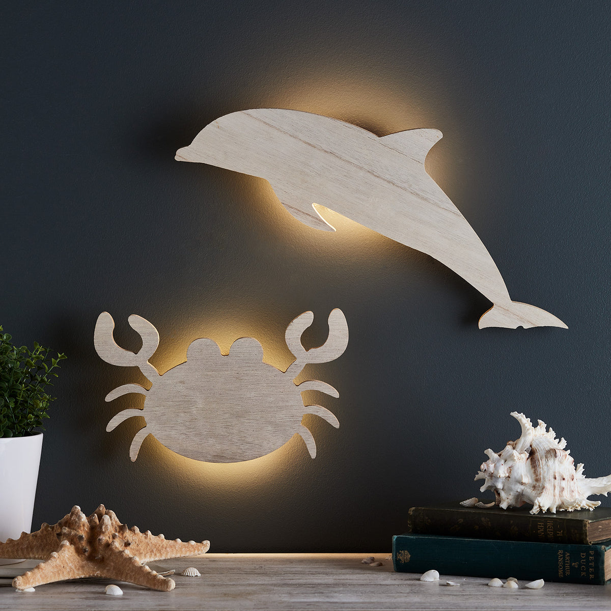 Beleuchtete Delfin- und Krabben-Wandlampen aus Holz an dunkler Wand