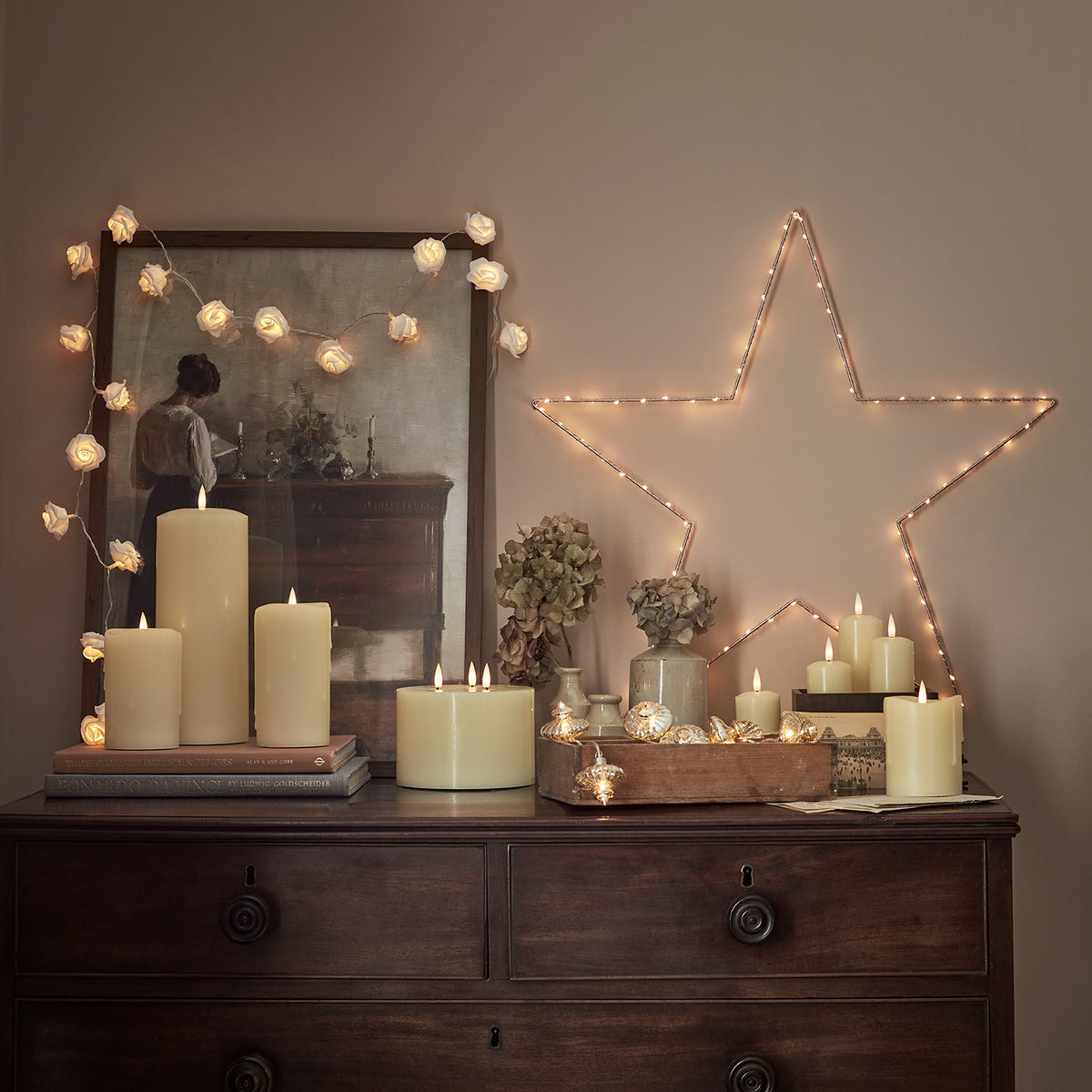 Romantische Dekoration mit Rosen Lichterkette, Kerzen und Stern aus Lichterkette an Wand