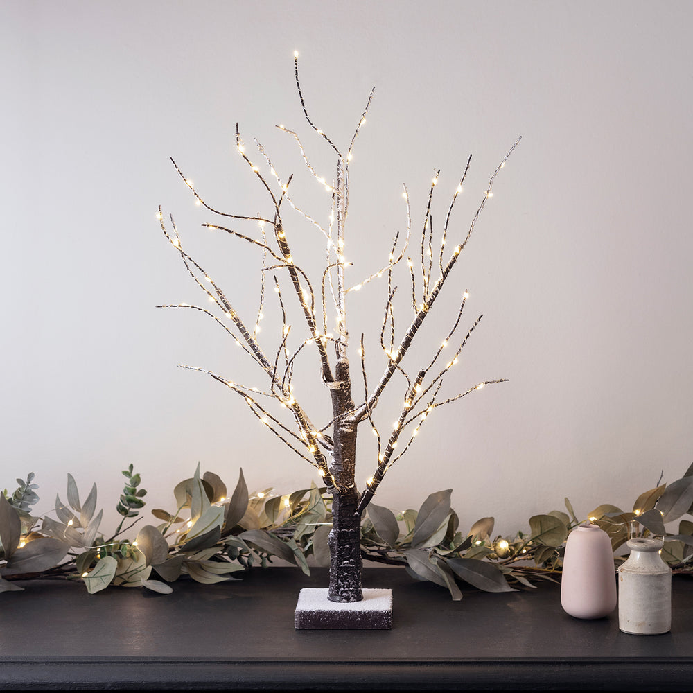 Kleiner LED-Baum vor Eukalyptus Girlande.
