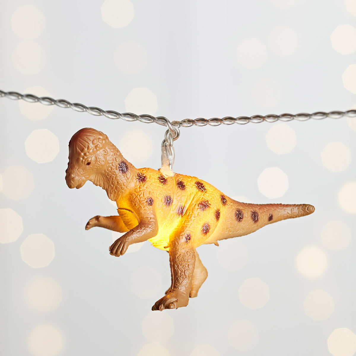 Nahaufnahme leuchtender brauner Dinosaurier Anhänger an Lichterkette