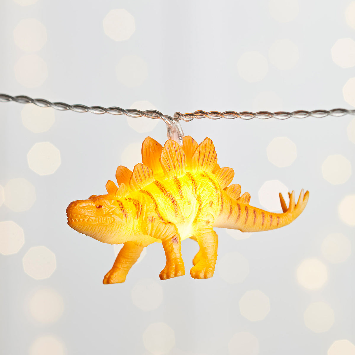Leuchtender orangefarbener Dinosaurier Anhänger an Lichterkette