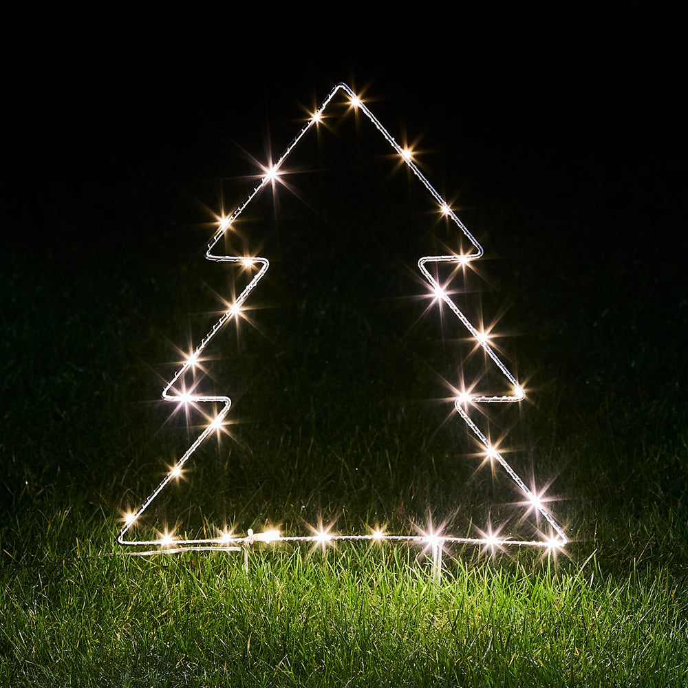 Leuchtender Micro LED Tannenbaum aus Metallrahmen auf Gras bei Nacht