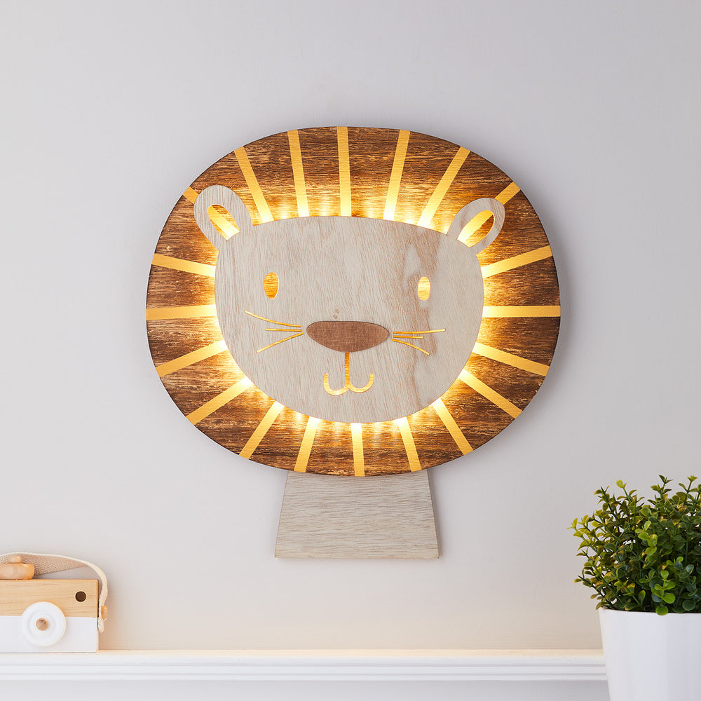 Löwen Wandlampe aus Holz mit warmweißen LEDs an der Mähne, leuchtend an weißer Wand
