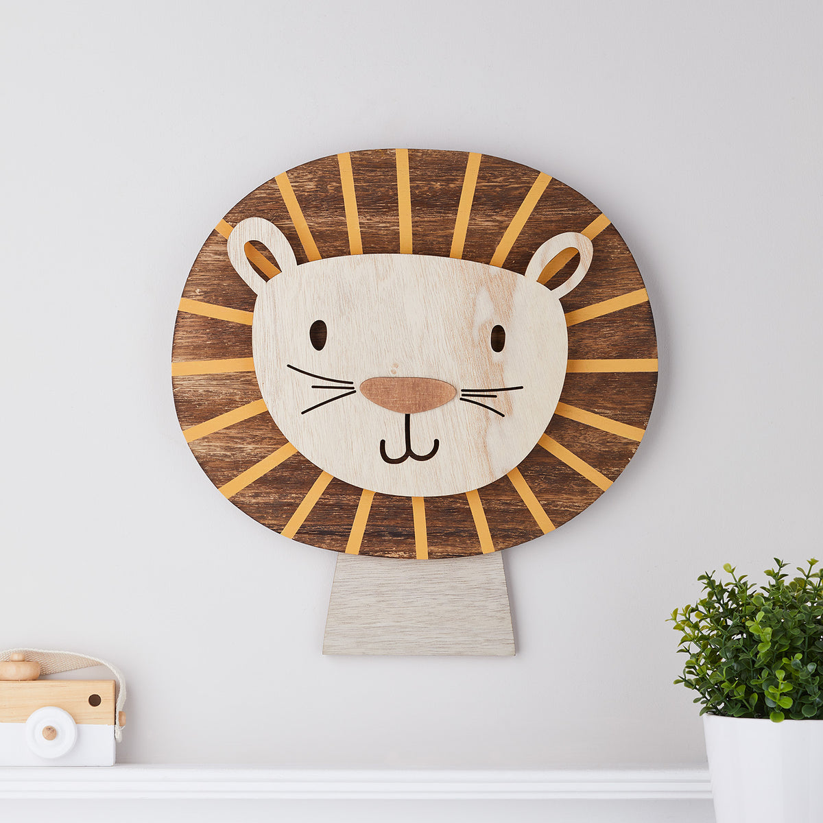 Löwen Wandlampe aus Holz ohne Beleuchtung, mit sichtbarer Holzmaserung an weißer Wand