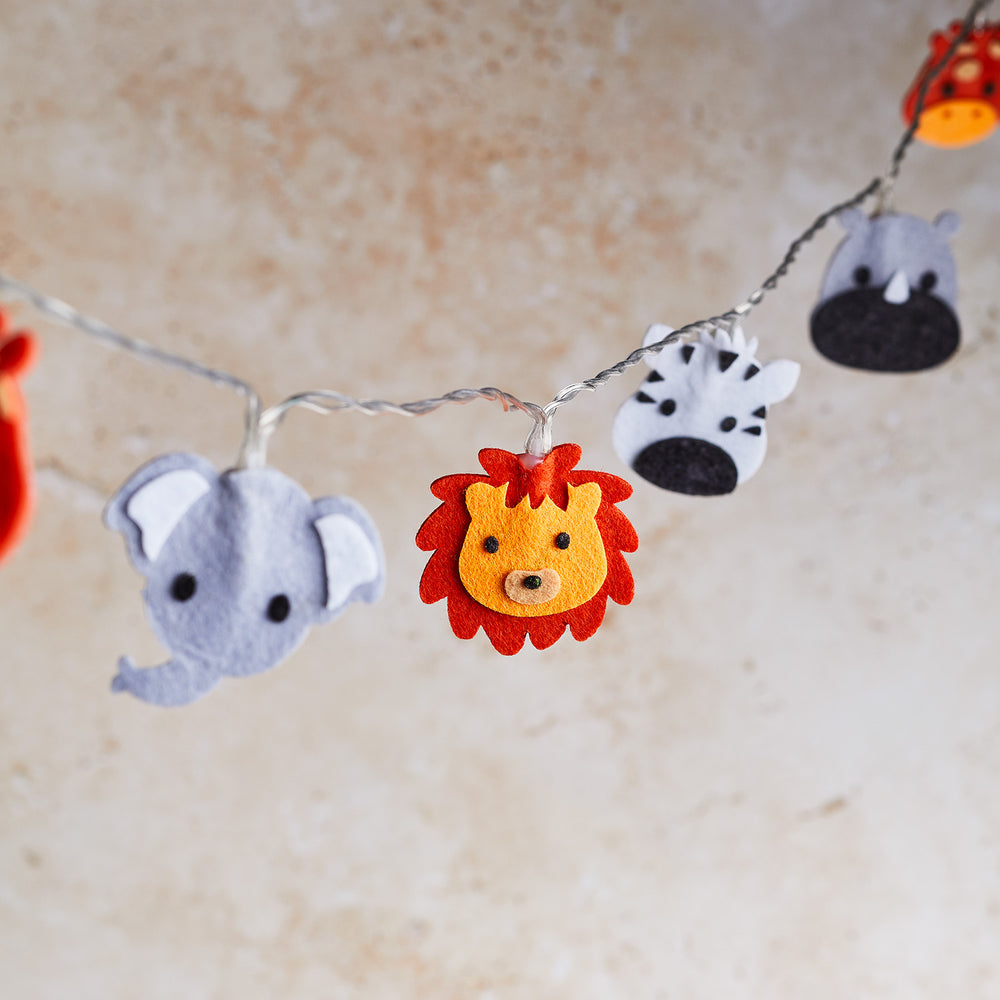 Safari-Filztiere Löwe, Elefant, Zebra und Nashorn an transparenter Lichterkette ohne Beleuchtung