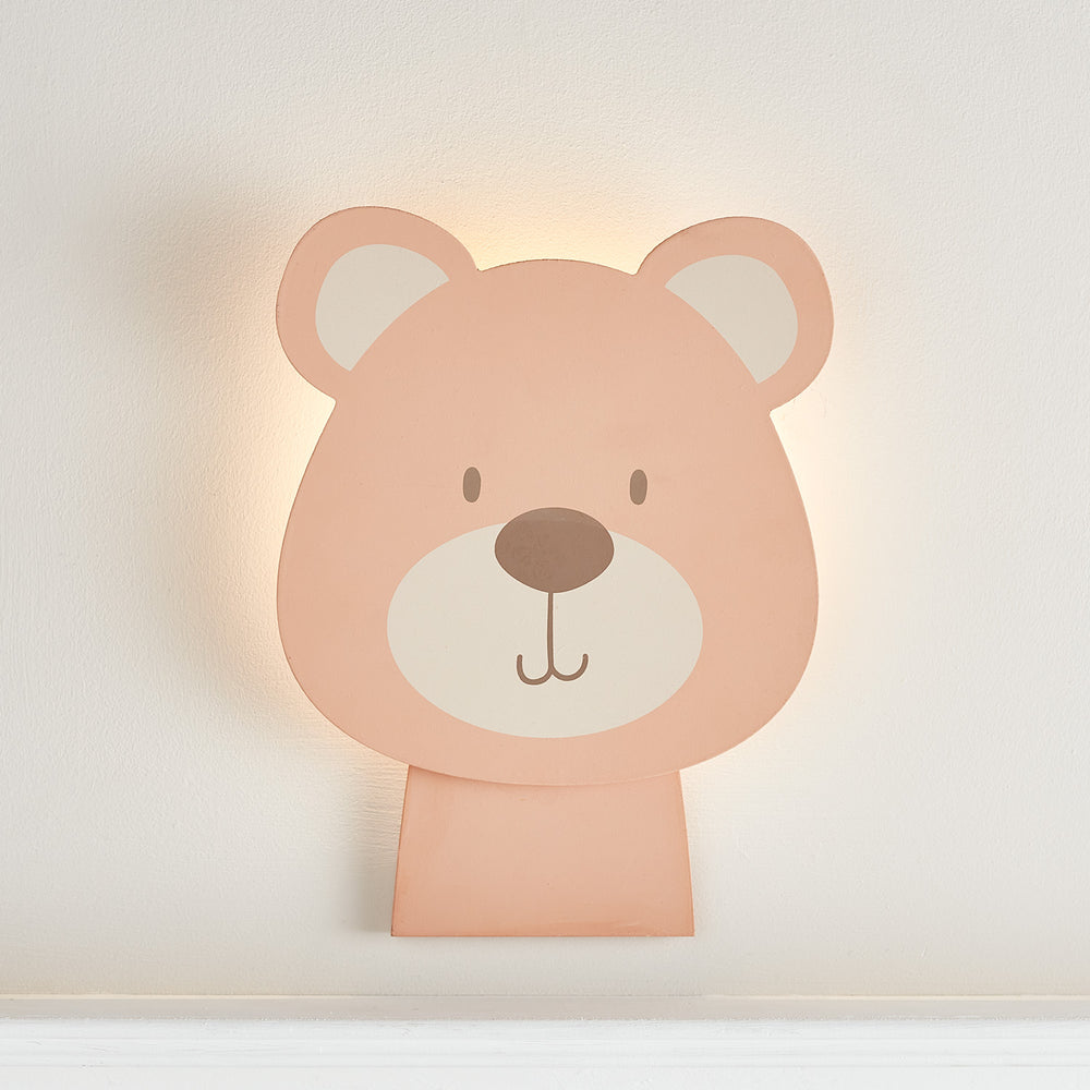 Holzwandlampe in Bärenform mit warmweißem Licht an weißer Wand