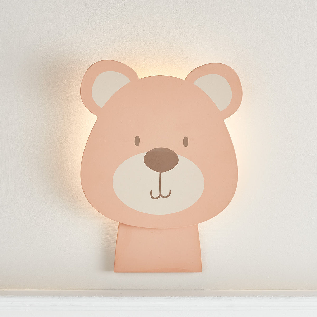 Holzwandlampe in Bärenform mit warmweißem Licht an weißer Wand