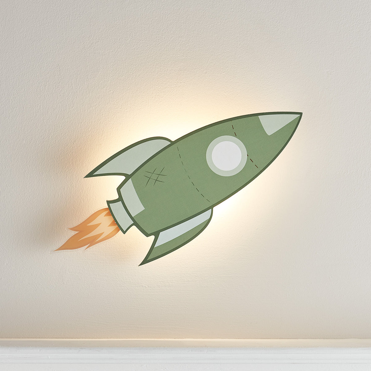 Grüne Raketen-Wandlampe mit LED-Beleuchtung an weißer Wand, seitliche Ansicht