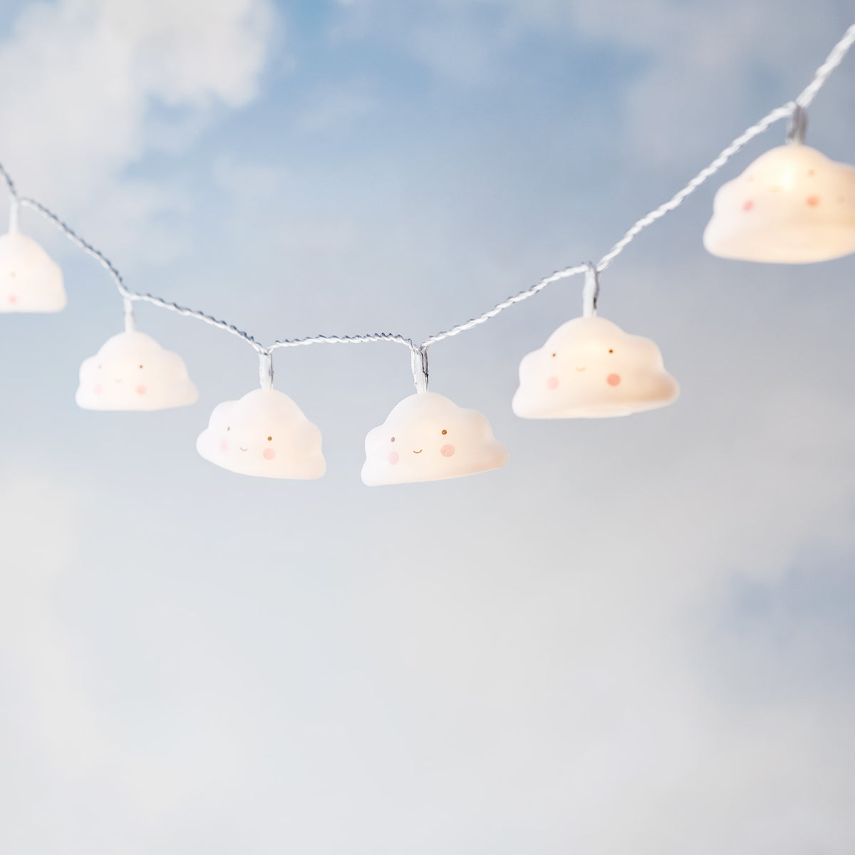 Lichterkette mit zehn leuchtenden Wolken mit rosigen Wangen vor blauem Himmel